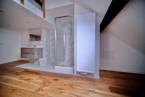 La salle de bains blanche est pourvue d'une douche et d'un lavabo. dans l'établissement Smart Appart - Bossaerts, à Bruxelles
