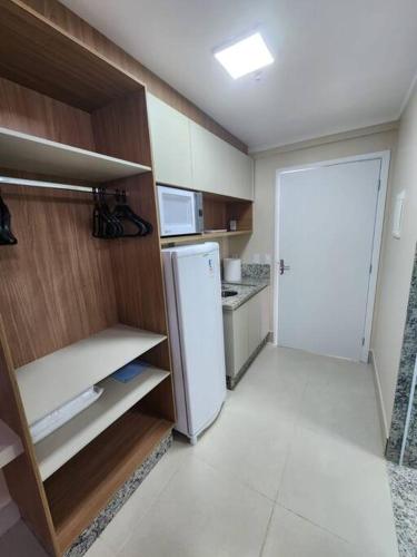 a kitchen with a white refrigerator and a door at DiRomaAp540Spazzio parque Splash in Caldas Novas