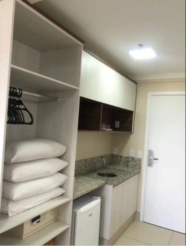 a room with a kitchen with white towels at DiRomaAp540Spazzio parque Splash in Caldas Novas