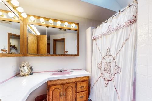 a bathroom with a sink and a shower curtain at Rascals Oceanfront Retreat in Florence