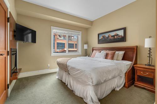 ein Schlafzimmer mit einem Bett und einem Flachbildfernseher in der Unterkunft Adventurer's Escape~ Mountain Luxury Resort in Canmore