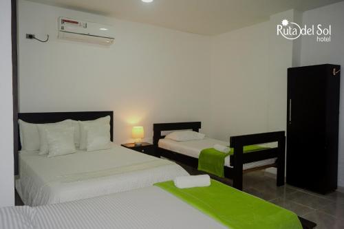 Habitación de hotel con 2 camas con sábanas verdes en HOTEL RUTA DEL SOL, en Barrancabermeja