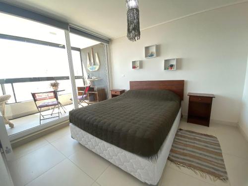 1 dormitorio con cama y ventana grande en Depto con Vista al Mar en Costa de Montemar. en Concón