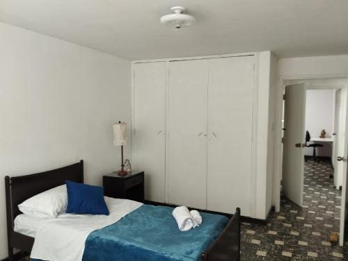 een slaapkamer met een bed en een grote kast bij AYARANA SAN FERNANDO Habitación Cali in Cali