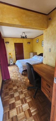 a bedroom with a bed and a desk with a computer at Alojamiento La Serena CQ in La Serena
