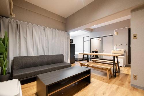 a living room with a couch and a table at TasoneUrbanStayOsaka なんば日本橋南不夜城706 in Osaka