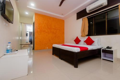 馬諾麗的住宿－OYO Manori Resort，一间卧室配有红色枕头的床