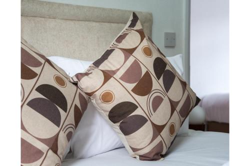 two pillows sitting on top of a bed at Lovely Home - Park Views & Ideal Transport Links in London