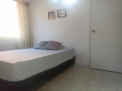 a bedroom with a bed with a pillow on it at Habitación laureles la Castellana 2 in Medellín