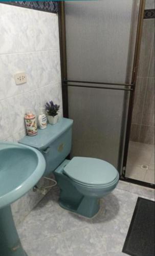 a bathroom with a blue toilet and a sink at Habitación laureles la Castellana 2 in Medellín