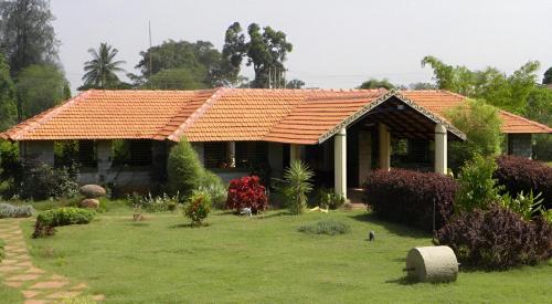 uma casa com um telhado de azulejos laranja num quintal em Palaka Resorts & Water Sports 