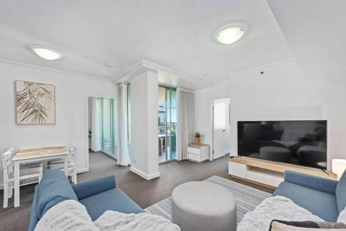 a living room with a blue couch and a tv at City Heights! 2Bed/1Bath/1Car/Views ~ CBD in Brisbane