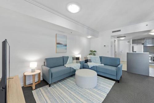a living room with a blue couch and a table at City Heights! 2Bed/1Bath/1Car/Views ~ CBD in Brisbane