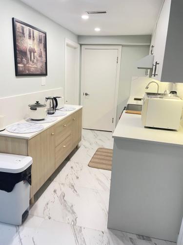 - une cuisine avec un sol en marbre blanc et un évier dans l'établissement Arbutus violet room, à Vancouver