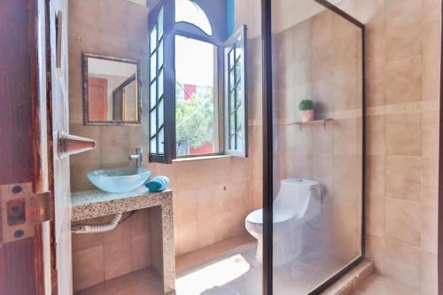 a bathroom with a shower and a sink and a toilet at HOSTAL ROMA in Mexico City