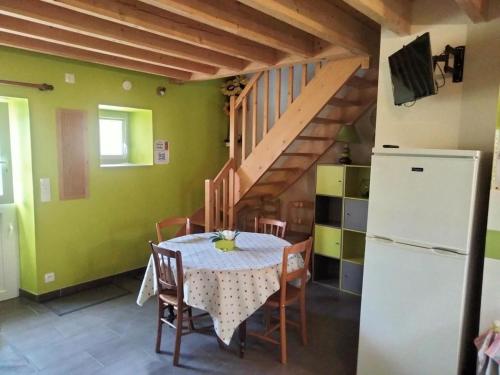 une salle à manger avec une table et un réfrigérateur dans l'établissement Gîte confort aux portes des châteaux, jardin, terrasse, WIFI, vélos, proche A85 et balades nature - FR-1-381-502, à Cigogné