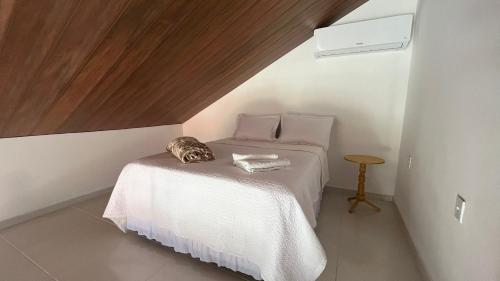 a small bedroom with a bed with a wooden ceiling at Villa Suíça, Chalé Mezanino in Tianguá