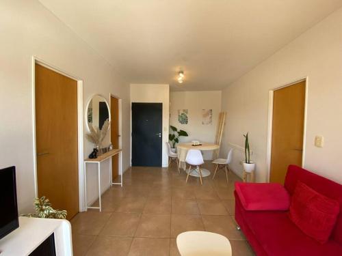 a living room with a red couch and a table at Departamento centrico en Tigre con Piscina y cochera incluida in Tigre