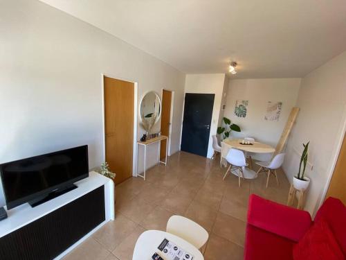 a living room with a flat screen tv and a table at Departamento centrico en Tigre con Piscina y cochera incluida in Tigre