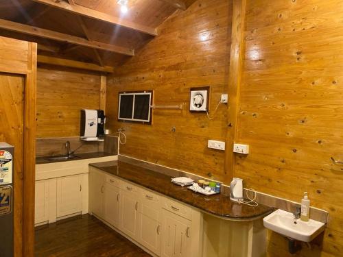 a bathroom with wooden walls and a sink and a counter at TREKKING TRAILS ECO STAY in Kalpetta