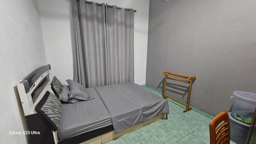 a small bedroom with a bed and a curtain at Boegas View Guesthouse in Vaikaradhoo