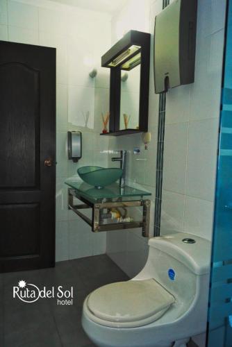 a bathroom with a toilet and a glass sink at HOTEL RUTA DEL SOL in Barrancabermeja