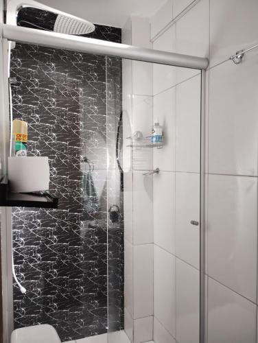 bagno con doccia e porta in vetro di Milton Bandeira flat a Viçosa