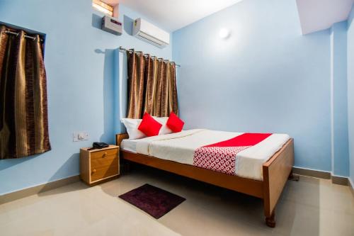 a bedroom with a bed with red pillows and a window at OYO Flagship Adam's Bridge International Hotel in Patna