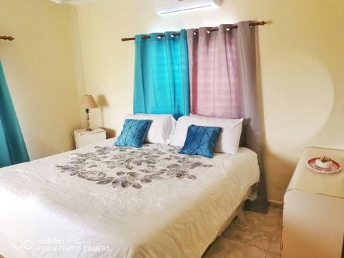 um quarto com uma cama grande e cortinas azuis em Villa Milly Cabrera 