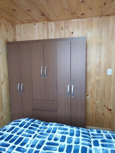 um quarto com armários de madeira e uma cama em Cricri em Castro