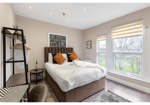 um quarto com uma cama grande e uma janela em Brand New Homey and Stylish Perfect for Travellers em Londres