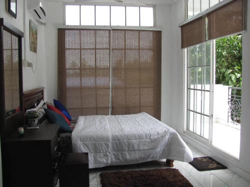a bedroom with a bed and two windows at White House in Wattala