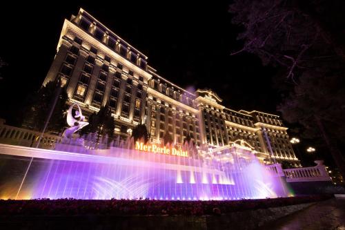a large building with a fountain in front of it at MerPerle Dalat Hotel in Da Lat