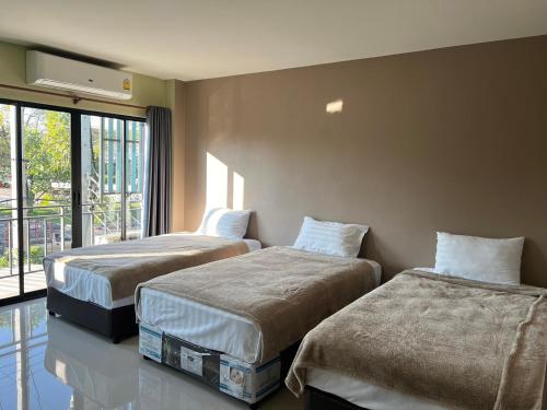 um quarto de hotel com duas camas e uma janela em V Tharm Hotel em Udon Thani
