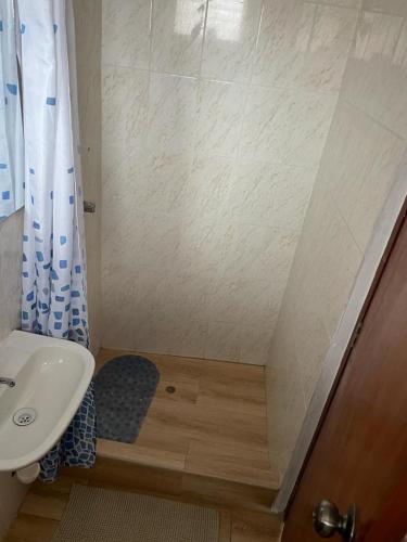 y baño pequeño con lavabo y ducha. en Hotel Hispano, en Cajamarca