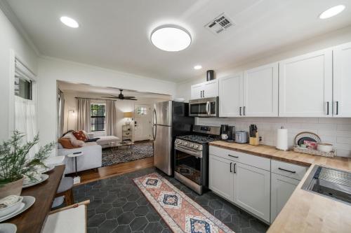 a kitchen with white cabinets and a dining room at Next to Expo, 5 beds, Hot-tub, corn hole, pets! in Tulsa