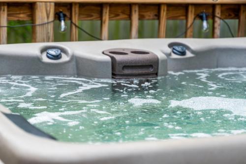 a bath tub filled with green water with at Next to Expo, 5 beds, Hot-tub, corn hole, pets! in Tulsa