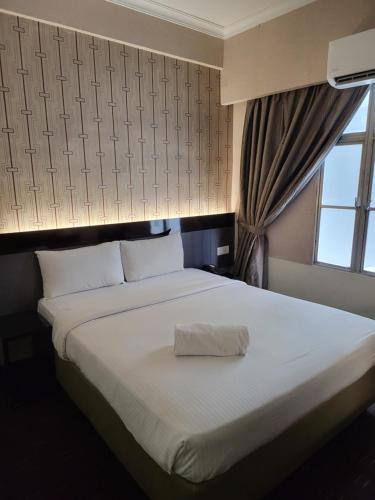 a bedroom with a large white bed with a window at Avaria KL in Kuala Lumpur