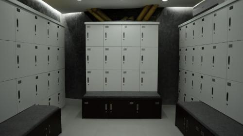 a locker room with white lockers and a black bench at Kalea Villas in Kuta Lombok
