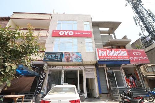 a white car parked in front of a building at OYO Hotel Dezzire in Ballabgarh