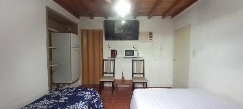 sypialnia z łóżkiem oraz kuchnia z kuchenką mikrofalową w obiekcie Los Cactus Planta Alta w mieście La Rioja