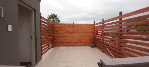 a wooden privacy fence with a palm tree behind it at Los Cactus Planta Alta in La Rioja