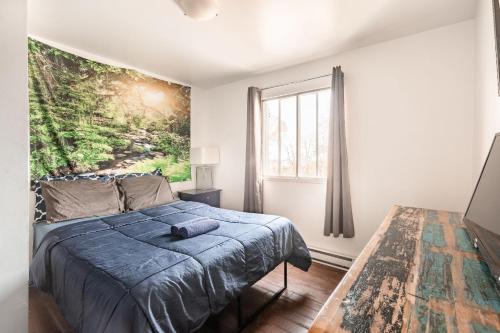een slaapkamer met een bed en een groot raam bij Appartement 3 chambres - 2234 in Montreal