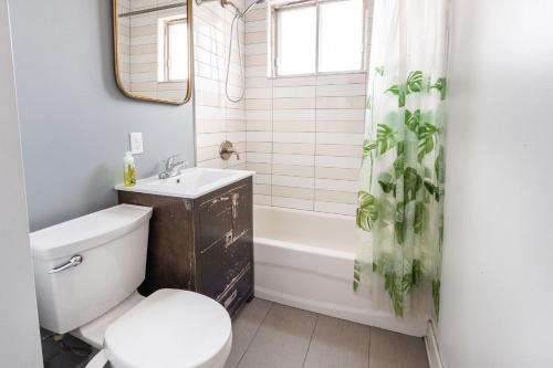 een badkamer met een toilet, een wastafel en een bad bij Appartement 3 chambres - 2234 in Montreal