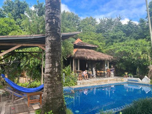 un complexe avec une piscine et une maison dans l'établissement Buzzas @ Pai Chan, à Pai