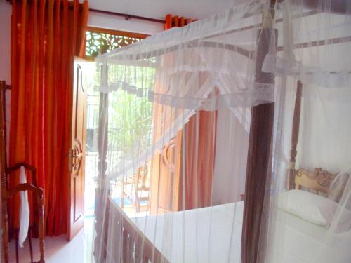 a room with a window with red curtains at Aayu's Guest in Bentota
