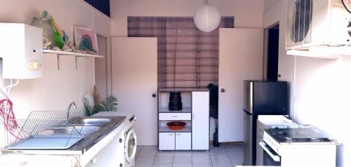 uma cozinha com um lavatório e um fogão em Fare Auti em Atiue