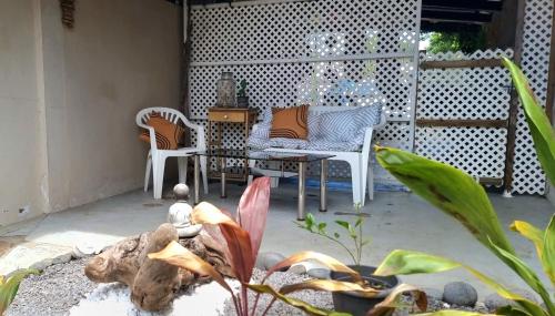 un patio con 2 sillas, una mesa y un sofá en Fare Auti, en Atiue