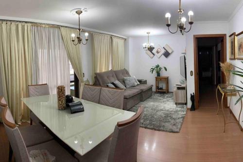 ein Wohnzimmer mit einem Tisch und einem Sofa in der Unterkunft Apartamento Central COM 02 BOX de garagem in Caxias do Sul