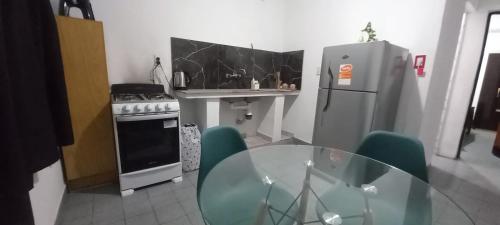 a kitchen with a glass table and a refrigerator at Los Cactus in La Rioja